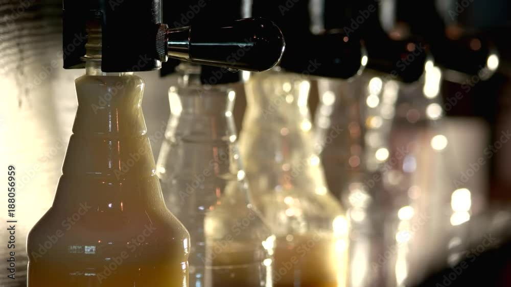 Beer filling bottles and overflow, close up. Foam overflowing out of