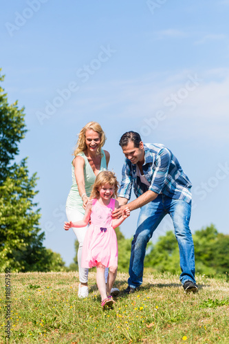 family playing catch or tag in summer outdoors © Kzenon