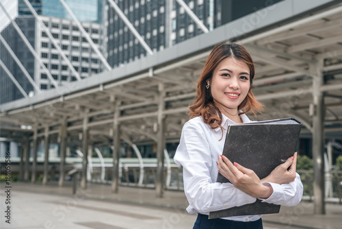 Portraits of beautiful asian woman look cheerful and confidence is standing in outdoors while feeling success with work.