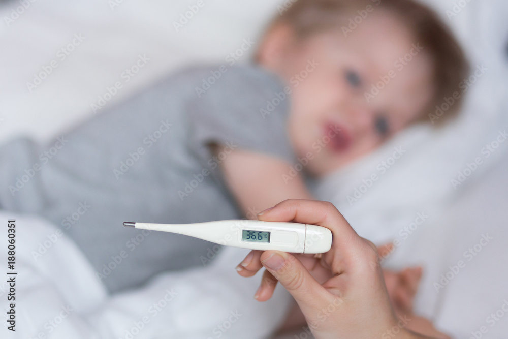 Close-up thermometer with normal body temperature 36,6. Mother measuring temperature of her kid. Close-up thermometer with normal body temperature 36,6. Mother measuring temperature of her kid.