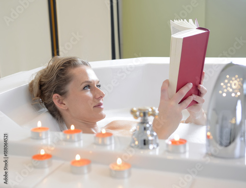 Frau liest Buch in Badewanne