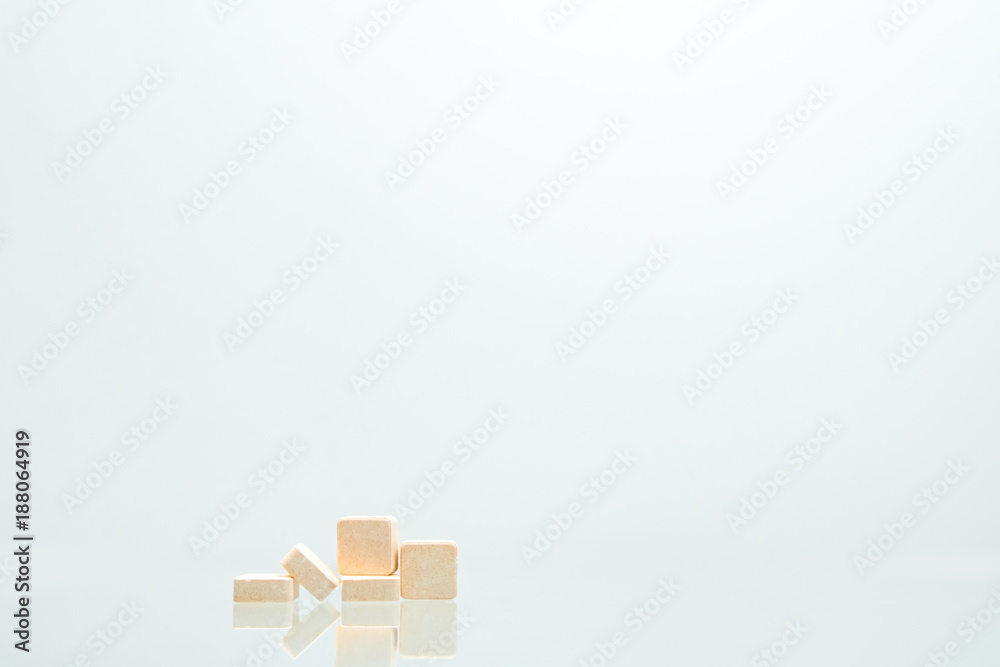 Five orange square tablets pills isolated on white background with shadows and copy space for text. Medical lozenges for relief cough, sore throat and throat irritation. Orange flavored Five orange square tablets pills isolated on white background with shadows and copy space for text. Medical lozenges for relief cough, sore throat and throat irritation. Orange flavored