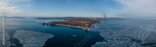 Lighthouse at Cape Basargin, Golden Horn Bay, Vladivostok symbol. Russky island. Landscape panorama. Sea of Japan.