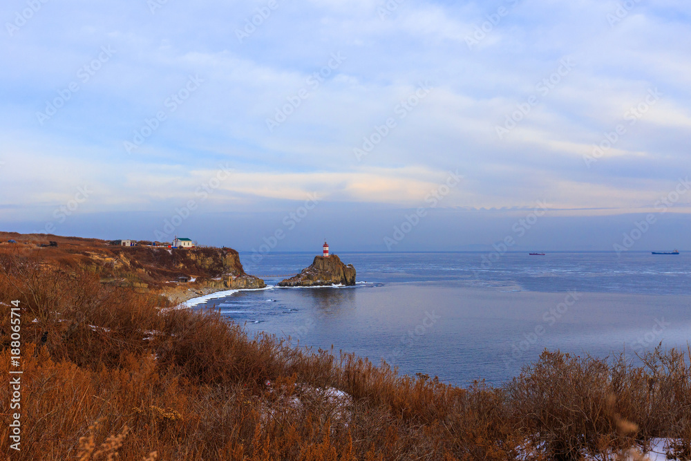 Lighthouse at Cape Basargin, Golden Horn Bay, Vladivostok symbol. Russky island. Landscape panorama. Sea of Japan.