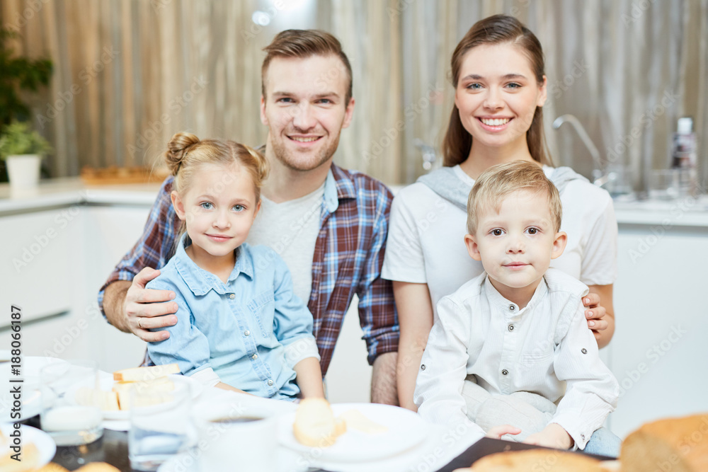 Two adorable kids and their happy parents spending time together at home Two adorable kids and their happy parents spending time together at home