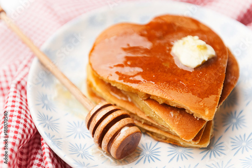 Fototapeta Naklejka Na Ścianę i Meble -  heart shaped pancakes on a light background. the concept of a festive breakfast for Valentine's Day or a pleasant surprise for a loved one