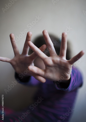 A little girl is afraid and tries to protect herself