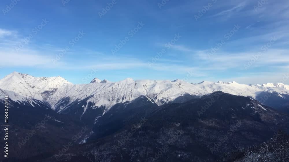 a landscape of snow-capped Caucasian mountains, snow caps of peaks against the blue sky a landscape of snow-capped Caucasian mountains, snow caps of peaks against the blue sky