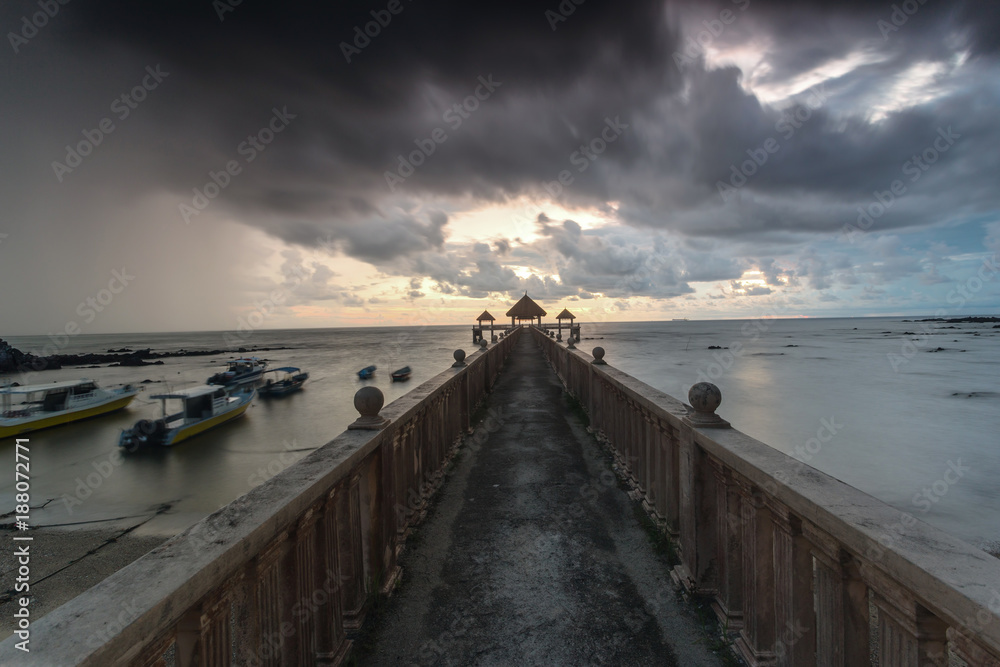 Long exposure Cloudy sunrise shot at jetty. Image contain certain grain or noise and soft focus when view at full resolution