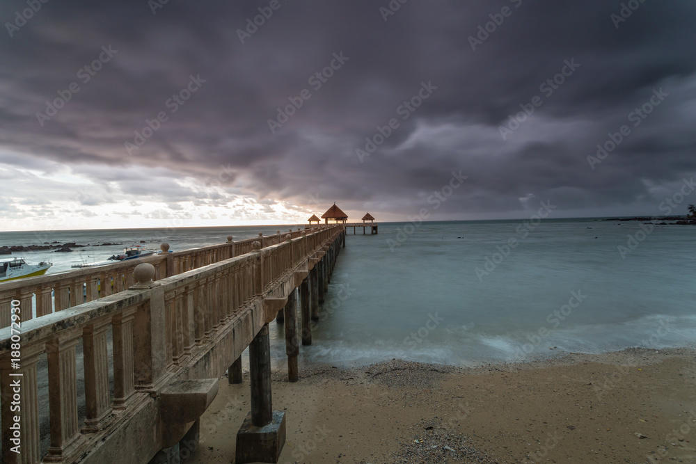 Long exposure Cloudy sunrise shot at jetty. Image contain certain grain or noise and soft focus when view at full resolution