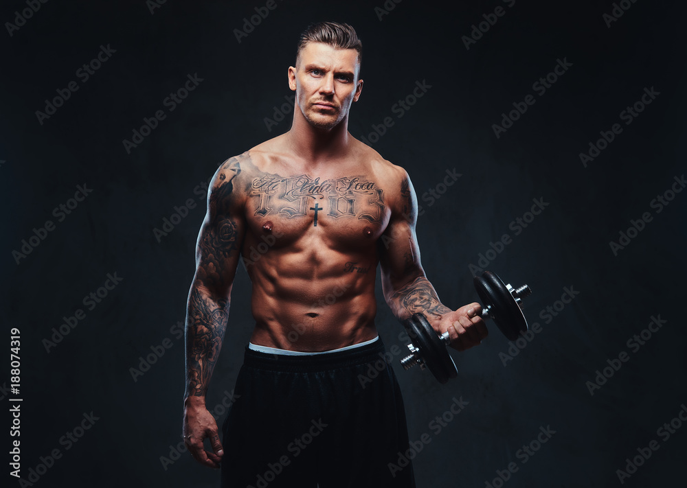 A muscular man doing exercises with dumbbells. A muscular man doing exercises with dumbbells.