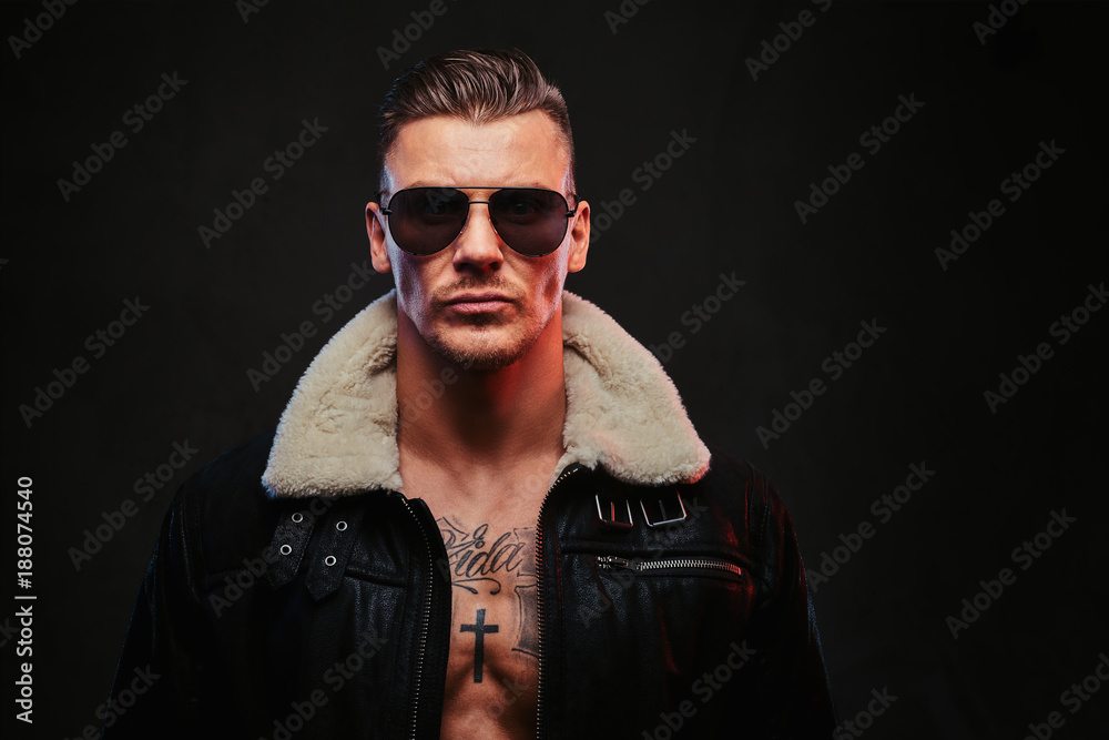A macho stylish man on a dark background. A macho stylish man on a dark background.