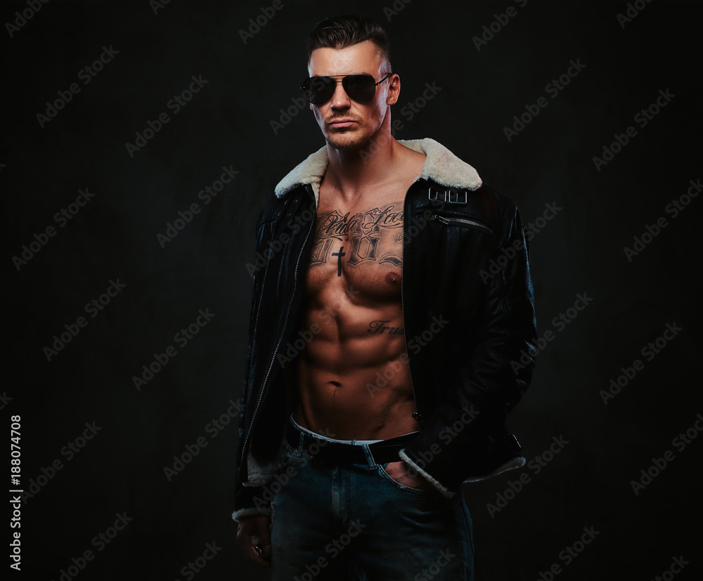 Fototapeta premium A macho stylish man on a dark background.