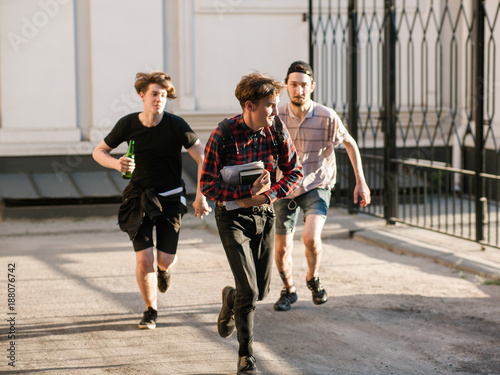 Konstfotografi stressed smart geek running away from street gang thugs