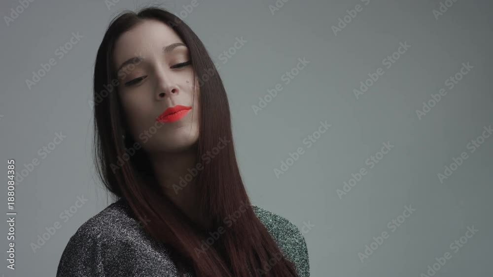 closeup of spanish woman with vivid orange matte lipstick in studio. Straight hair and ideal skin closeup of spanish woman with vivid orange matte lipstick in studio. Straight hair and ideal skin