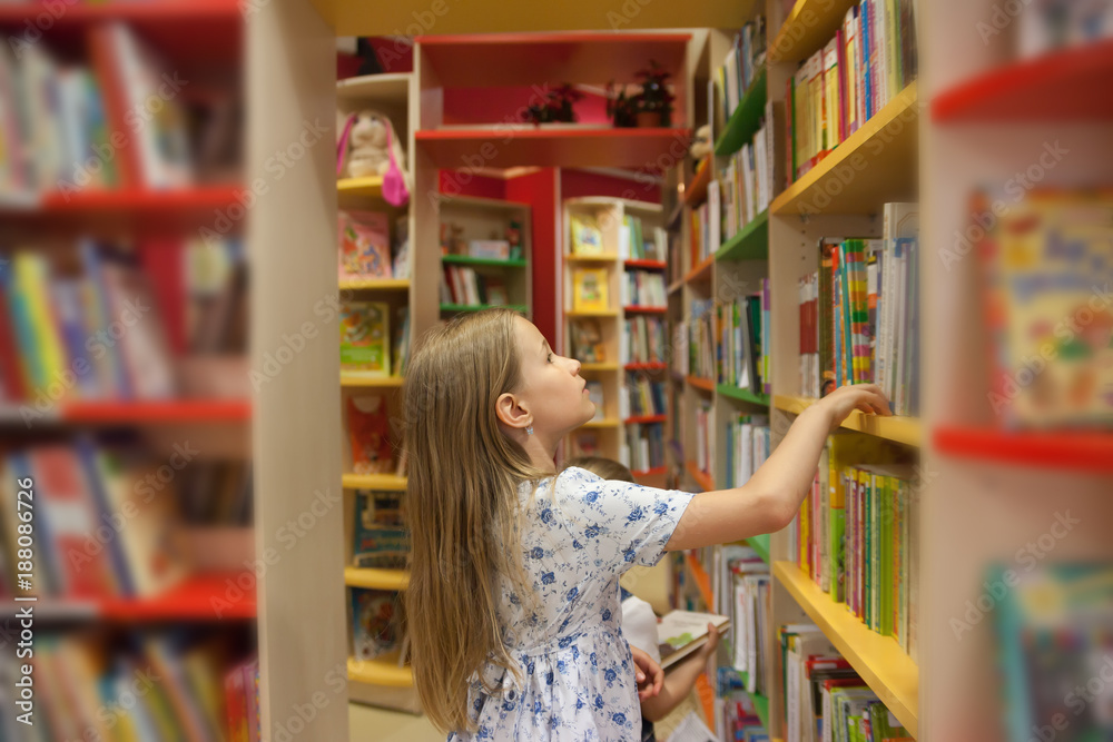 girl in library choosing books. girl in library choosing books.