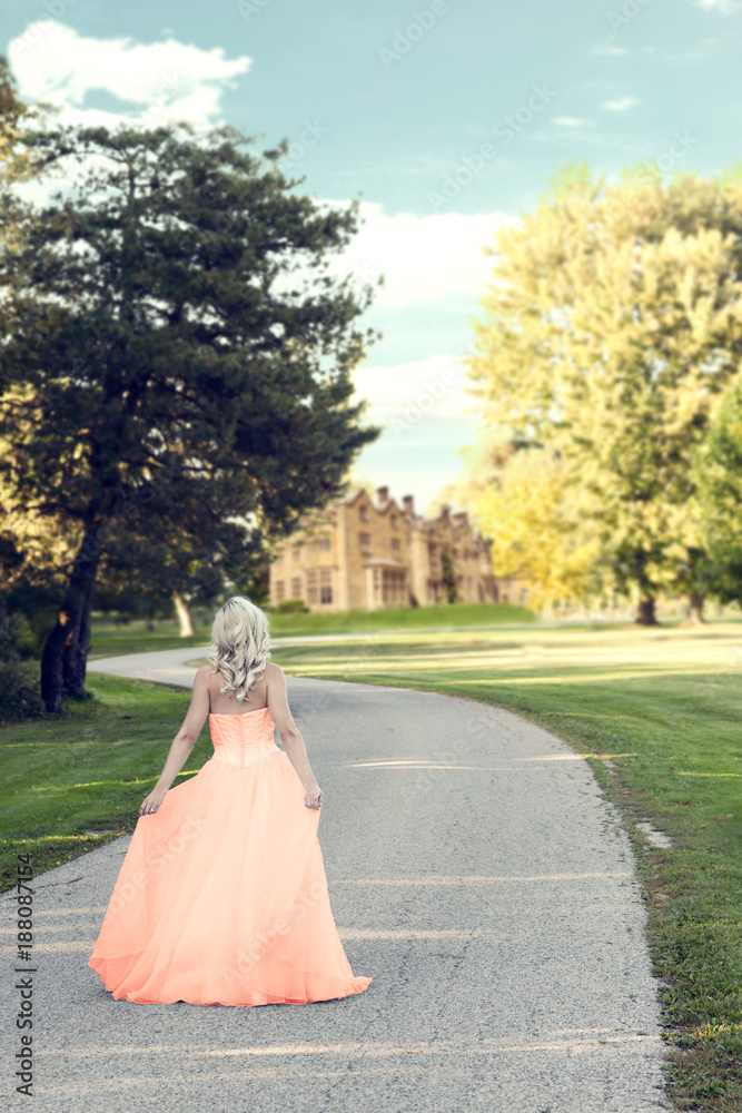 woman in evening dress walking to manor house woman in evening dress walking to manor house