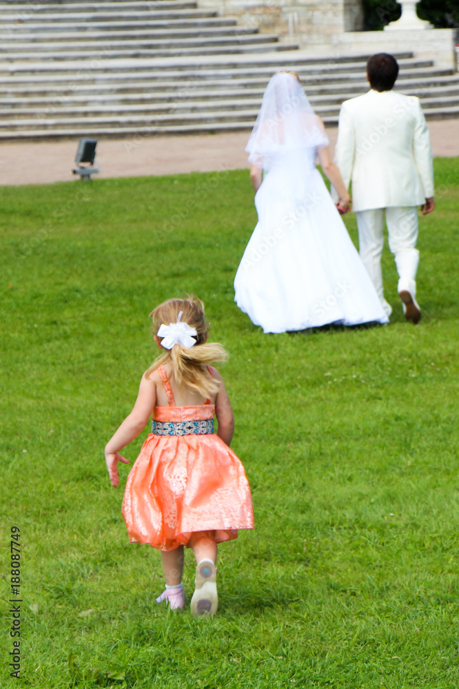 Fototapeta premium A beautiful girl is running after the newlyweds