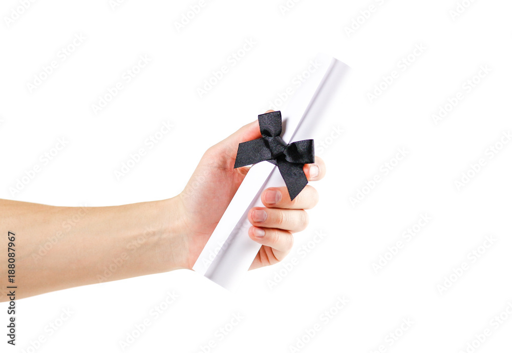 Hand holding scroll of white paper with a black bow on a white background. Closeup Hand holding scroll of white paper with a black bow on a white background. Closeup