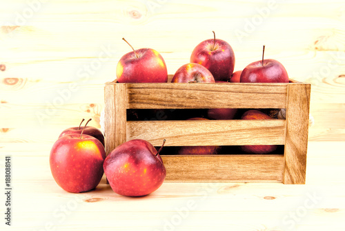 Fresh and delicious red  apples in a wooden crate on a white background . photo