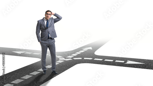 Young businessman at crossroads in uncertainty concept