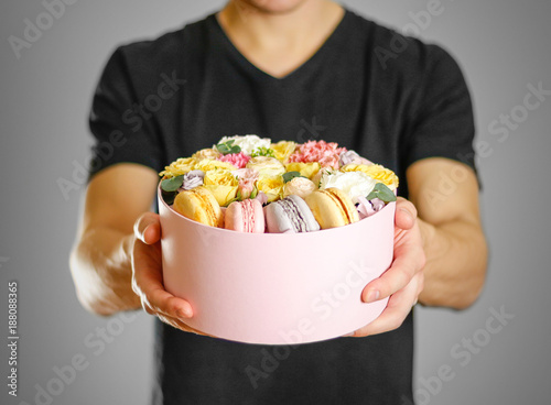 Man holding flowers and cookies in a box. Hands holding rocket in a hatbox © OB production