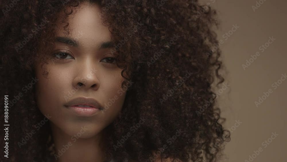 tilt moving camera showing closeup portrait of mixed race black woman in studio shoot
