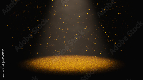 twinkling golden glitter falling through a cone of light on a stage 