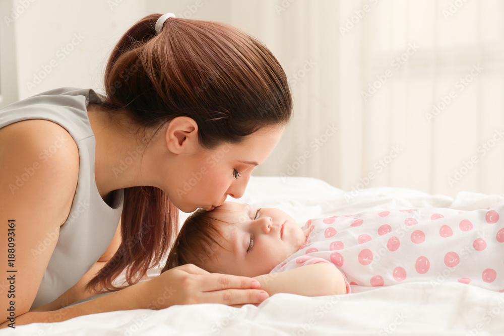 Young mother kissing her sleeping baby at home Young mother kissing her sleeping baby at home