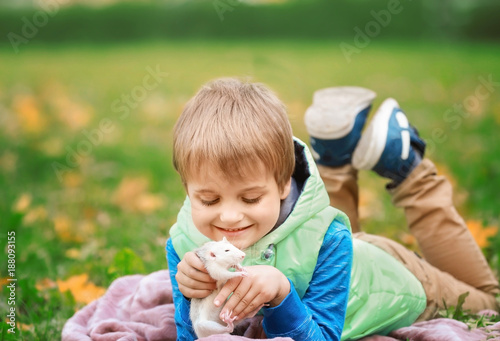 Little boy with cute pet rat in park