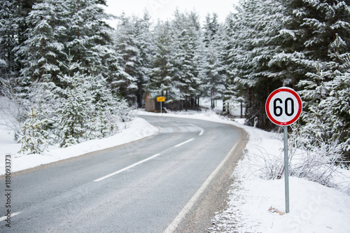 Mountain winter road with a speed limit sign © scharfsinn86