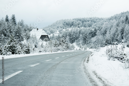 Mountain winter road goes through the village © scharfsinn86