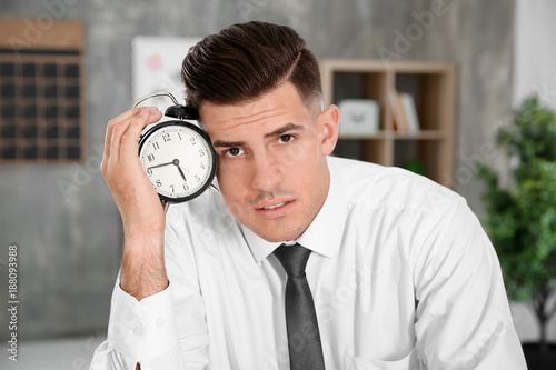 Tired manager holding alarm...