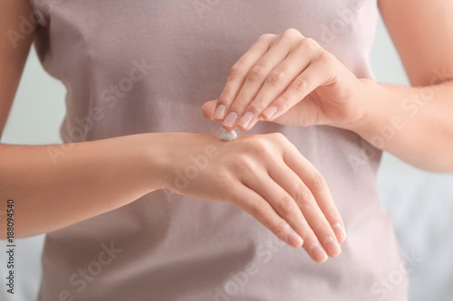 Young woman applying hand cream, closeup