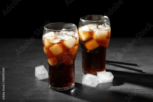 Cold cola in glasses on dark background