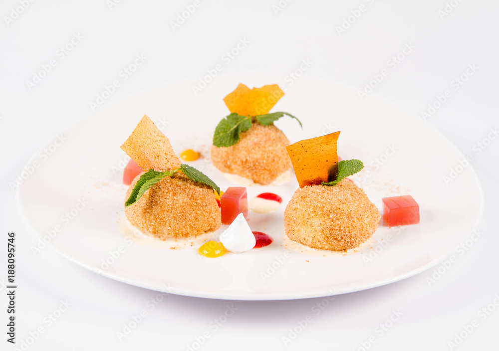 Plum dumplings with cinnamon, white chocolate and vanilla sauce on a white background Plum dumplings with cinnamon, white chocolate and vanilla sauce on a white background