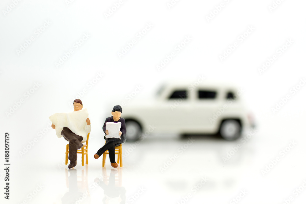 Miniature people: Businessman reading newspaper and sitting on brown chair. Image use for background education or business concept. Miniature people: Businessman reading newspaper and sitting on brown chair. Image use for background education or business concept.
