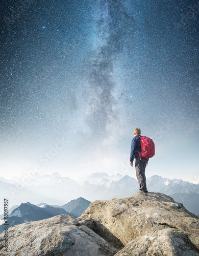 Tourist on high rocks on the high sky background. Sport and active life concept.