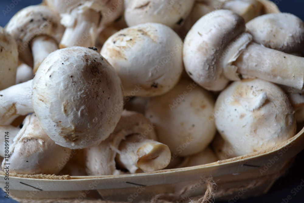 Mushrooms on the dark blue wooden desk. Cooking champignons. Mushrooms on the dark blue wooden desk. Cooking champignons.
