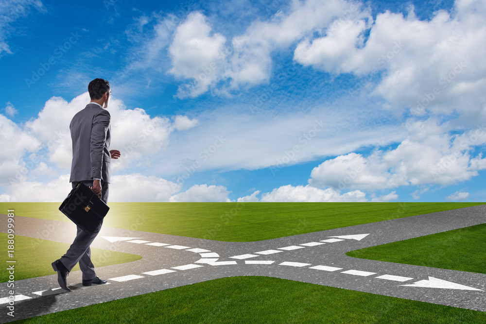 Young businessman at crossroads in uncertainty concept