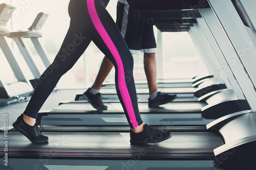 Woman's legs on treadmill in fitness club, healthy lifestyle