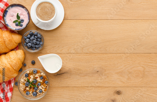 Continental breakfast with croissants and berries on natural wood