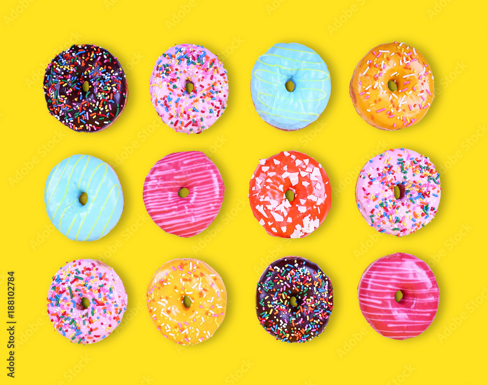 assorted variety of doughnuts on a yellow background studio shot overhead assorted variety of doughnuts on a yellow background studio shot overhead