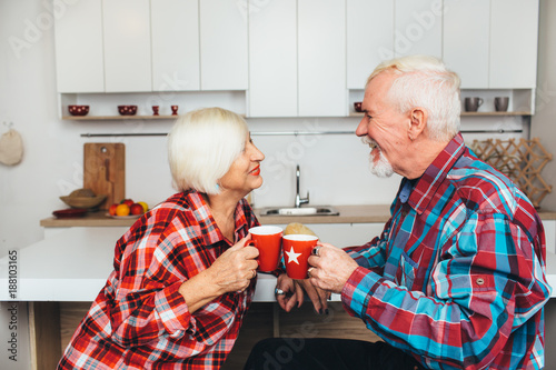 breakfast with a loved one, elderly men and women drink together latte, being at home in the kitchen