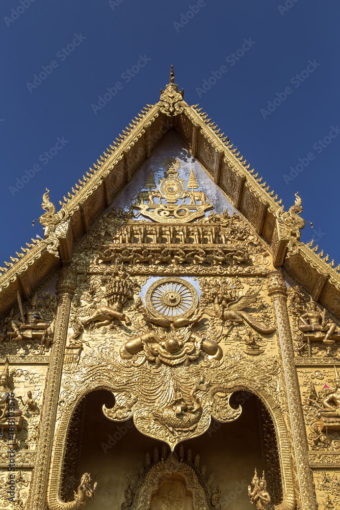 Fototapeta premium The gable apex of golden temple on blue sky background