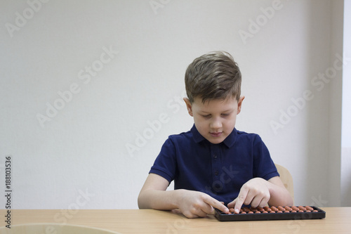 Mental arithmetic school. Boy counts with abacus in 