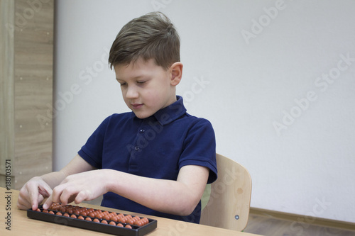 Mental arithmetic school. Boy counts with abacus in 