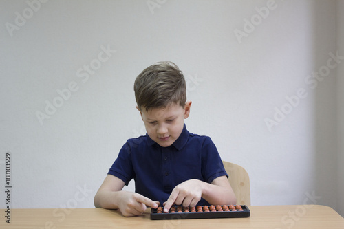 Mental arithmetic school. Boy counts with abacus in 