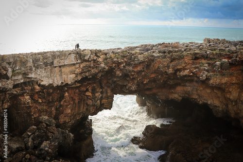 Big rock formation with a cave in the center with ocean water inside. Local known as 