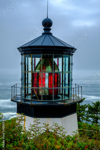 A closeup view of the Cape Meares Lighthouse Lanter Room and upper structures. The grey-blue skies add a dramatic tone.